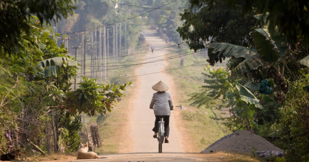 rustic scene in Mai Chau with a local riding through the countryside