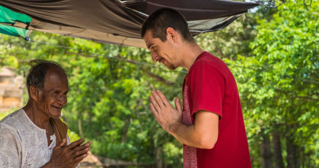 foriegner practising the local customs in Asia with a wai - travelling like a local in Asia with Discova