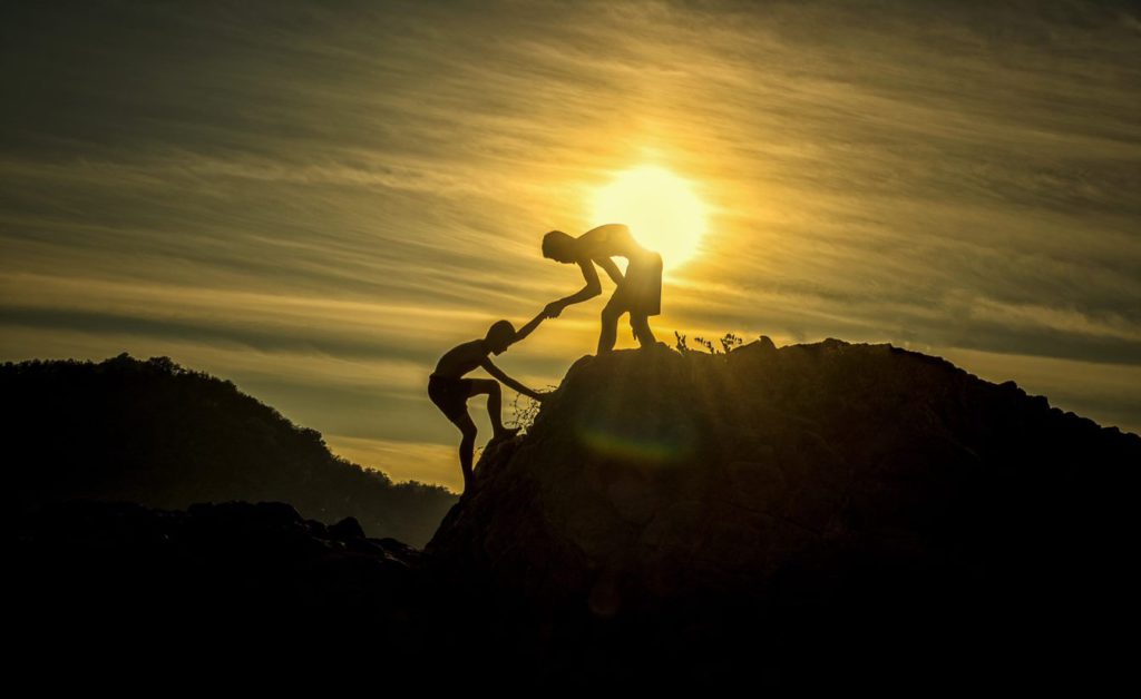 Giving someone a helping hand up a mountain