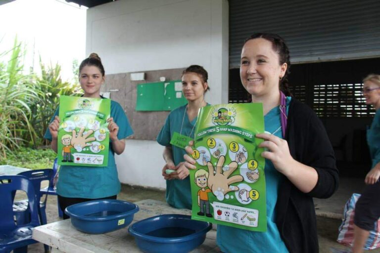 nurses hold educational posters about washing hands