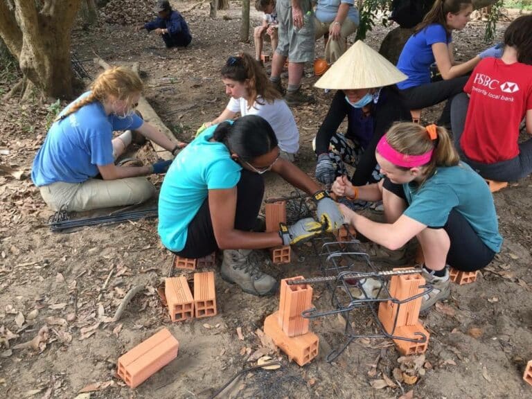 Service learning and community impact work in Mekong Delta, Vietnam - international students lay the foundations of a new house